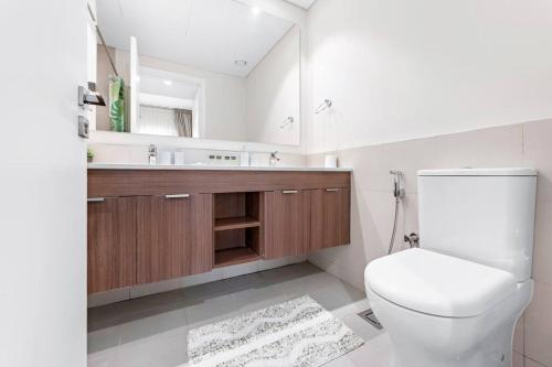 迪拜StoneTree - Spacious 2BR Apartment in Golf Views Block A的一间带卫生间、水槽和镜子的浴室