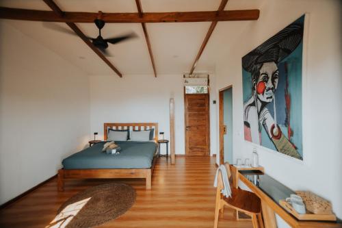 塞隆贝拉纳克Disini Lombok ECO Sky House, Selong Belanak的卧室配有一张床,墙上挂有绘画作品