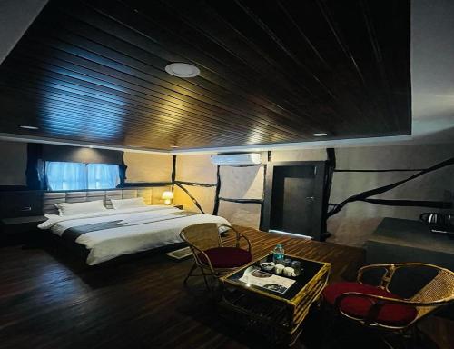 Jyoti GaonDaosri The Inn的卧室配有一张床和一张桌子及椅子