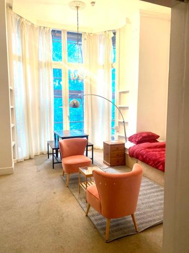 伦敦Large self-contained cozy studio的卧室配有一张床和一张桌子及椅子