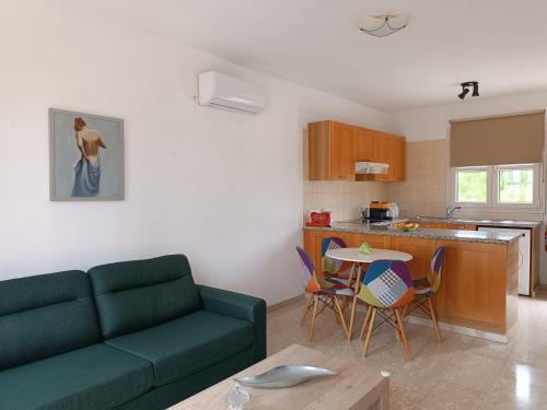 库克里亚Aphrodite Hills Adonis Apartment的带沙发和桌子的客厅以及厨房。