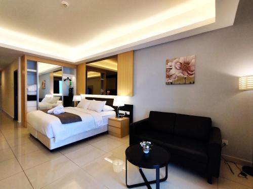 云顶高原TopGenting SunriseColdSuite4Pax @GrdIonDelmn的酒店客房,配有床和沙发