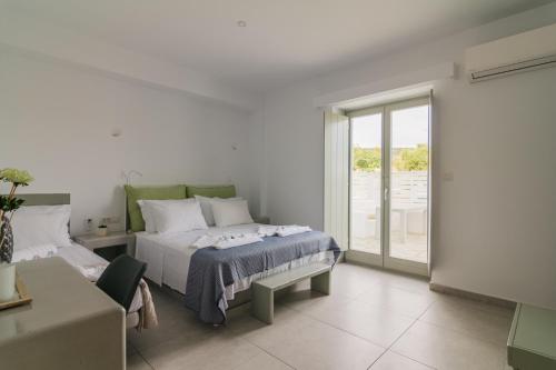 AngairiáOlive Garden Luxury Resort的一间卧室配有一张床、一张沙发和一个窗口