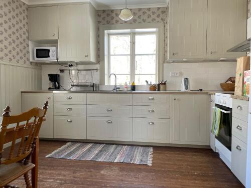 ÅråsÅrås Kvarn & Hostel的厨房配有白色橱柜和窗户。