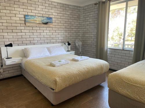 奥古斯塔Augusta Escape Holiday Units的一间卧室配有一张床,上面有两条毛巾