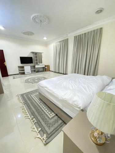 欧拉مشار العلا للشقق الفندقيه 1的一间卧室配有一张床和一张带台灯的桌子