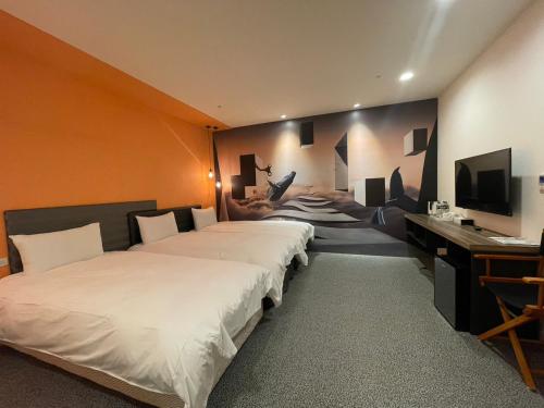 台中市凝萃文旅台中車站店 NCH - NingCui Business Hotel的客房设有两张床、一张桌子和一台电视机。