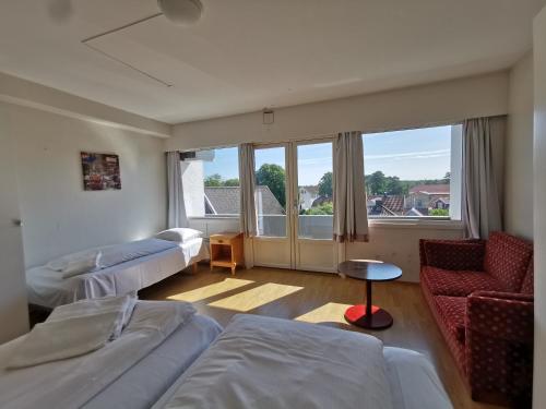 曼达尔SKAP Hostel Mandal的客房设有两张床、一张沙发和一个窗口。