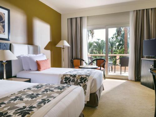 卢克索卢克索帕维隆冬季索菲特酒店的酒店客房设有两张床和一个阳台。