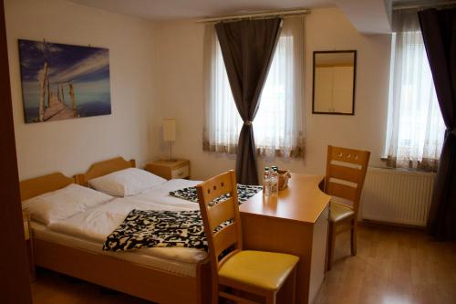 NakloPONI NAKLO - Sobe Marinšek的卧室配有一张床和一张桌子及椅子