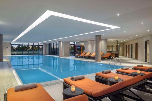巴统巴统希尔顿酒店的一座大型游泳池,里面设有橙色椅子
