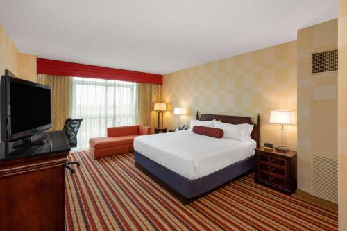 俄克拉何马城Wyndham Grand Oklahoma City Downtown的配有一张床和一台平面电视的酒店客房