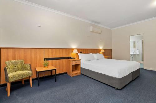 珀斯Metro Hotel Perth City的配有一张床和一把椅子的酒店客房