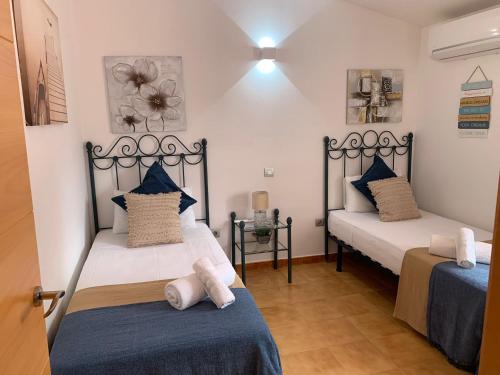 比尼贝卡Villa Abbas的一间设有两张蓝色和白色床铺的客房