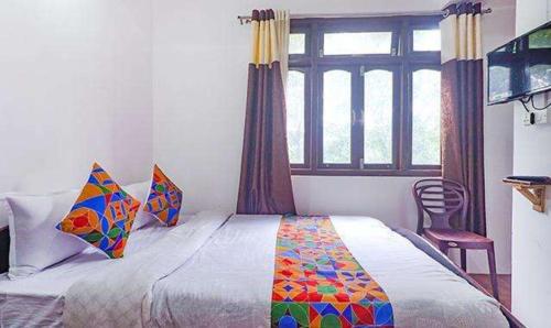 甘托克FabExpress Laxmi Niwas的一间卧室设有一张大床和一个窗户。