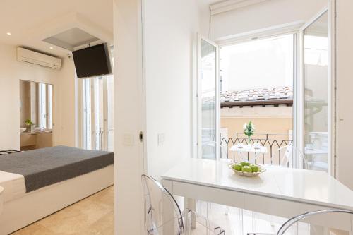 罗马Amazing 3 Levels Penthouse Piazza Venezia的白色的客房配有一张床和一张桌子及椅子