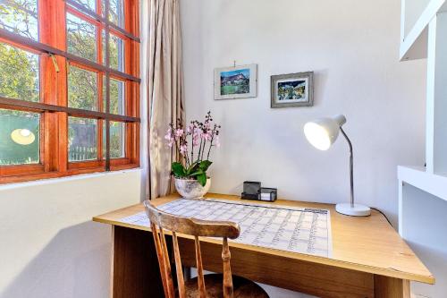 SandtonLonehill - Deluxe Garden Cottage 2的一个带桌子和灯的家庭办公室