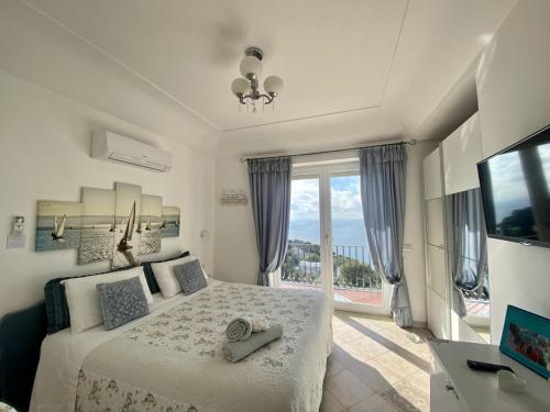 卡普里MARVELOUS SEA VIEW VILLA的白色的卧室设有床和大窗户