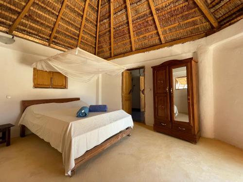 AnakaoChez Peter Pan Anakao的一间卧室设有一张床和木制天花板