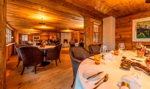 GontenAppenzeller Huus Bären的用餐室设有桌椅和木墙