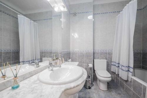 奥迪韦拉什Apart Lisboa confortavel 2 quartos com terraço的浴室配有盥洗盆、卫生间和浴缸。