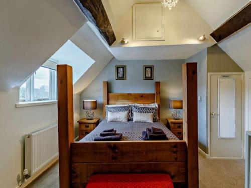 布里奇诺斯Beautiful 2 Bedroom Riverside Cottage的阁楼上的卧室配有一张大型木床