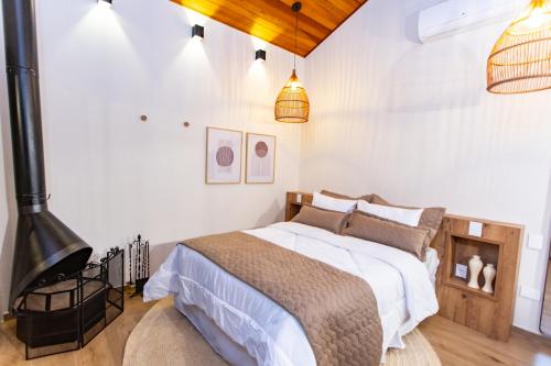 圣本图-杜萨普卡伊Chalés Quinta da Boa Vista的一间卧室配有一张带白色墙壁的床和壁炉