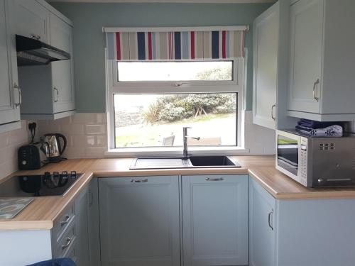 马根波思White Ocean的厨房配有白色橱柜、水槽和窗户。