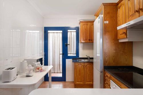 法马拉Casa Famara的厨房配有木制橱柜和蓝色门