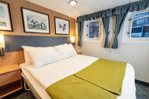 特罗姆瑟Quest的小型客房的一张床位,设有两个窗户