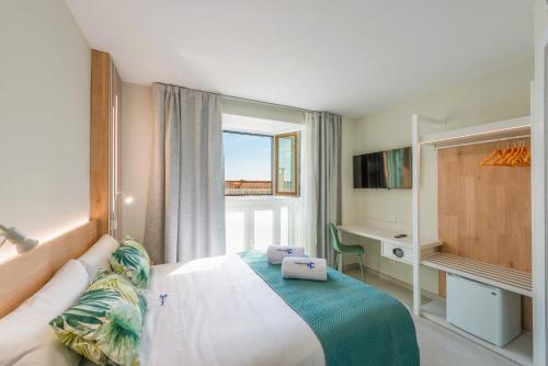 内尔哈HC Calahonda Beach Nerja的一间卧室配有一张床、一张书桌和一个窗户。