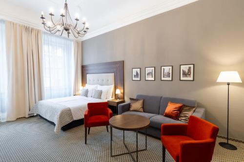 布拉格Hotel Ikona的一间卧室配有一张床、一张沙发和一张桌子