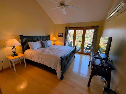 布雷顿森林CR16 Ski-in/Out luxury home mountain views Bretton Woods的一间卧室设有一张床和一个阳台