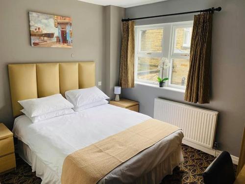 Liversedge利弗西奇酒店的一间卧室设有一张大床和一个窗户。