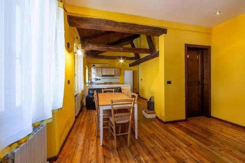 CasseroRelais Castel d'Emilio – Casa ARANCIO的用餐室设有黄色的墙壁和桌椅