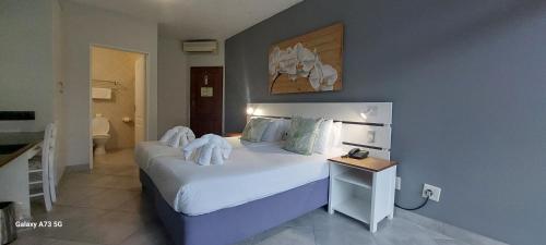 圣卢西亚大象湖酒店的卧室配有一张带白色床单和枕头的大床。