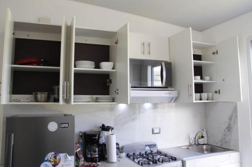 圣米格尔Residencial Privada Nueva San miguel, casa Flores的厨房配有白色橱柜、水槽和冰箱。