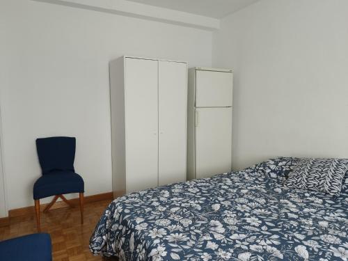 马德里Habitación luminosas en Vista Alegre的一间卧室配有一张床和一张蓝色椅子