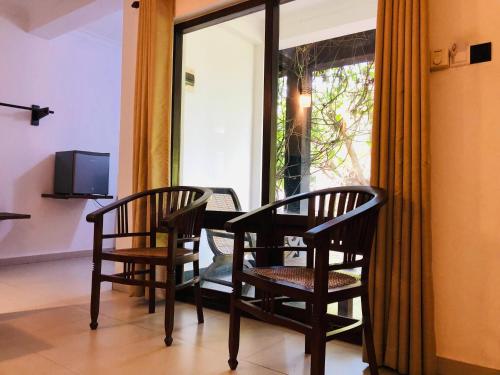 丹不拉丹布拉石拱门住宿加早餐旅馆的窗户客房内的两把椅子和一张桌子