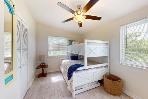 Summerland KeyAmada Grenada的卧室配有白色双层床和吊扇
