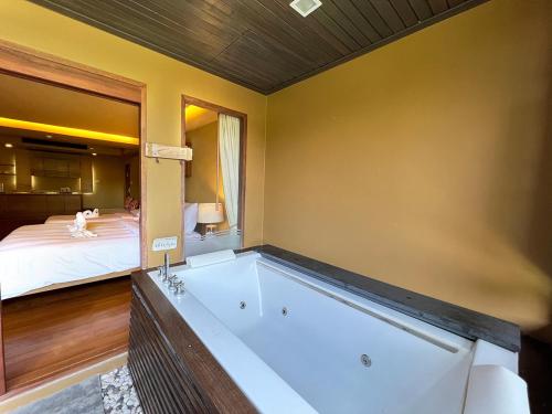曾蒙海滩Deva Beach Resort Samui的配有床的房间设有浴缸