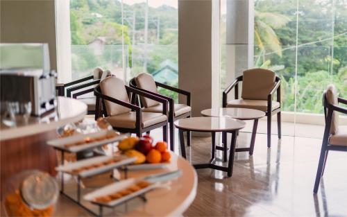 长滩岛Canyon Hotels & Resorts Boracay的一间设有椅子和一张桌子的房间,提供食品托盘
