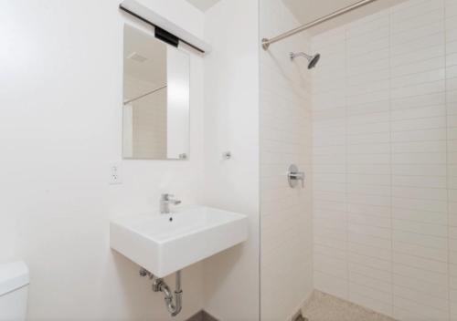纽约Amazing 4 Bedroom Apartment In Chambers Street的白色的浴室设有水槽和淋浴。