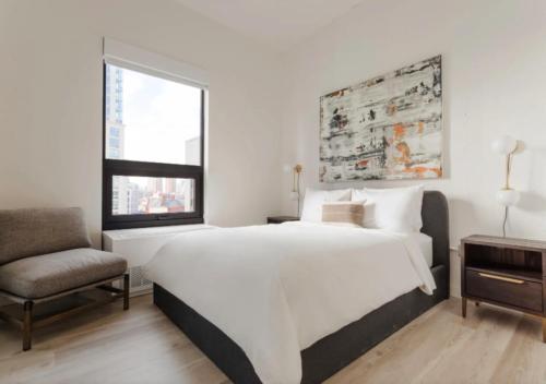 纽约Amazing 4 Bedroom Apartment In Chambers Street的白色卧室配有一张大床和椅子