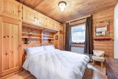 科瓦拉因巴迪亚Chalet Sassongher II的木制客房内的一间卧室配有一张大床