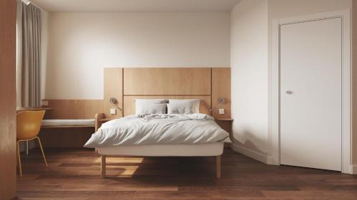 凯尔采B&B HOTEL Kielce Centrum的一间卧室配有一张大床和一张书桌