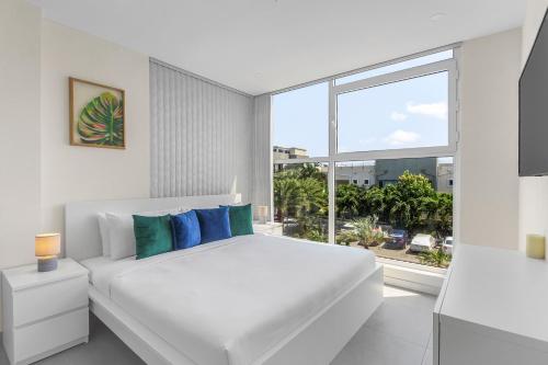 棕榈滩Bocobay Aracari Condo Hotel的白色的卧室设有床和大窗户