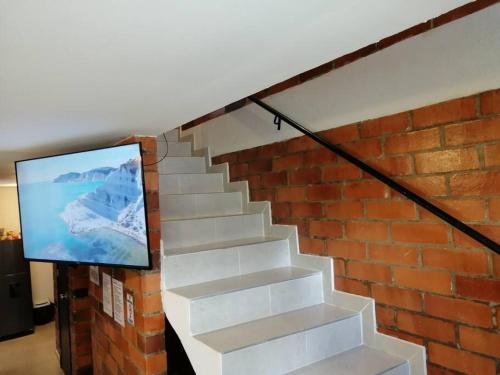萨兰托Orquidia 12的楼梯,有砖墙,上面有电视