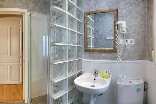 马德里Apartamentos Mayor Centro的一间带水槽、镜子和卫生间的浴室