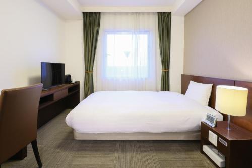 高松多美迎高松酒店的酒店客房设有床和窗户。